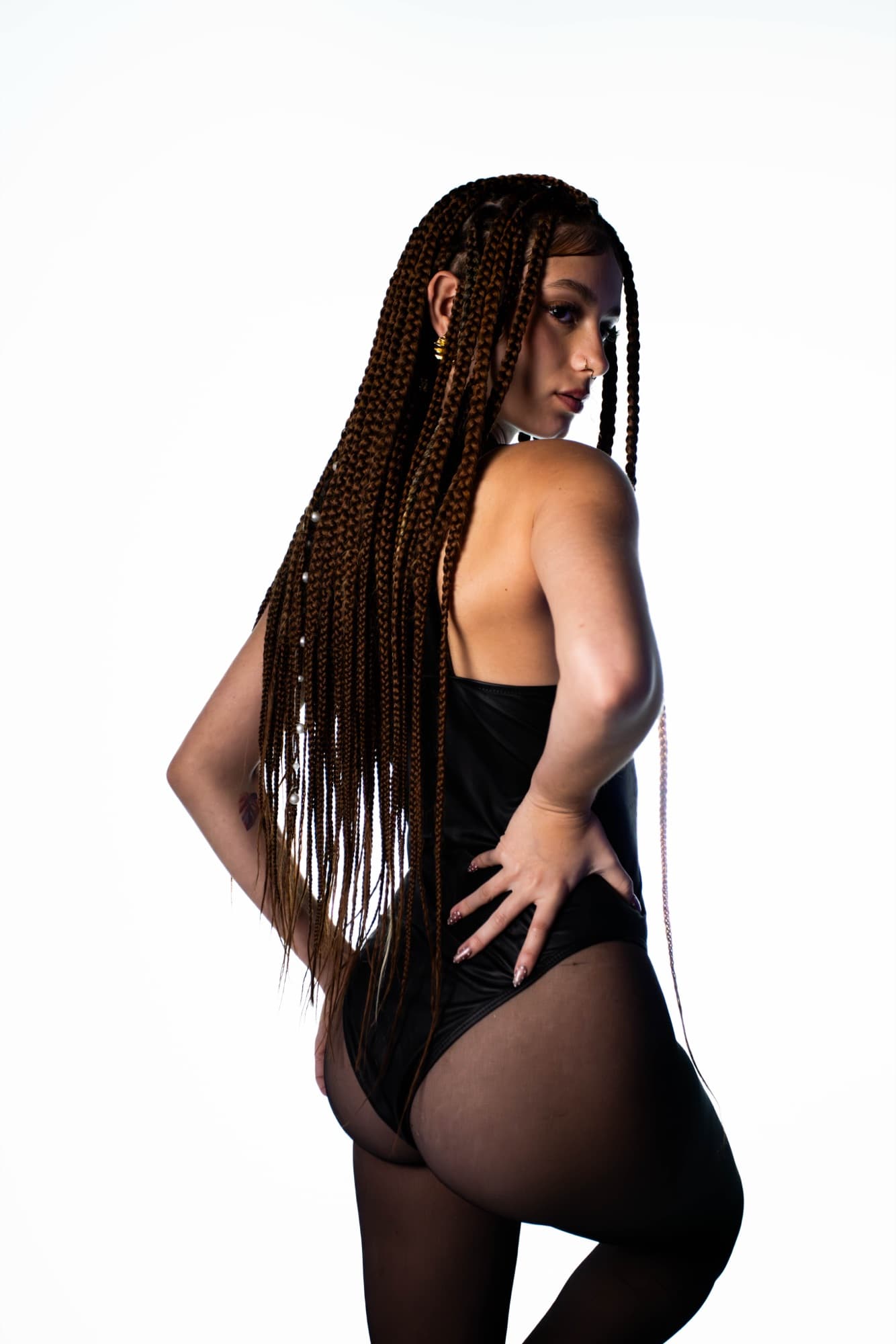 Back pose with a hand on the hip, braids cascading