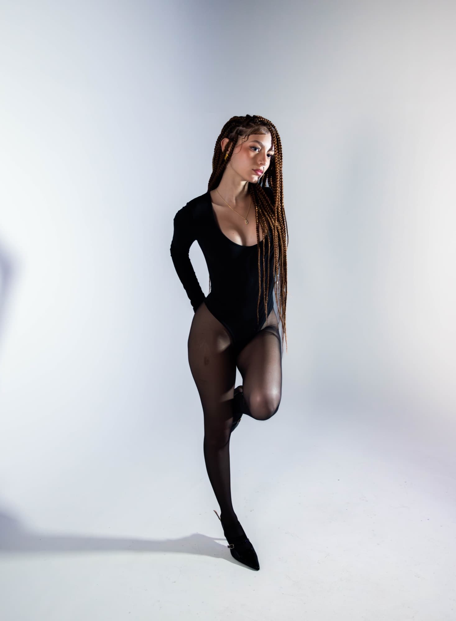 Standing pose in sheer tights, knee raised