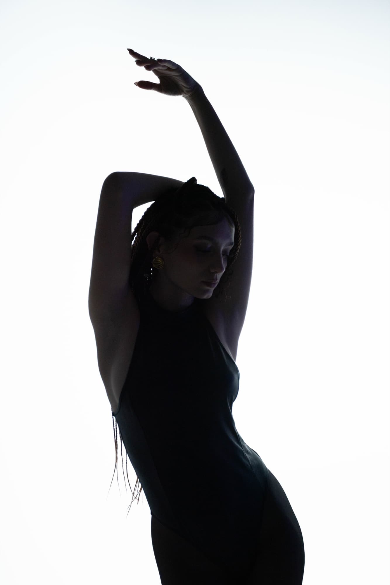Backlit silhouette with an arm raised overhead