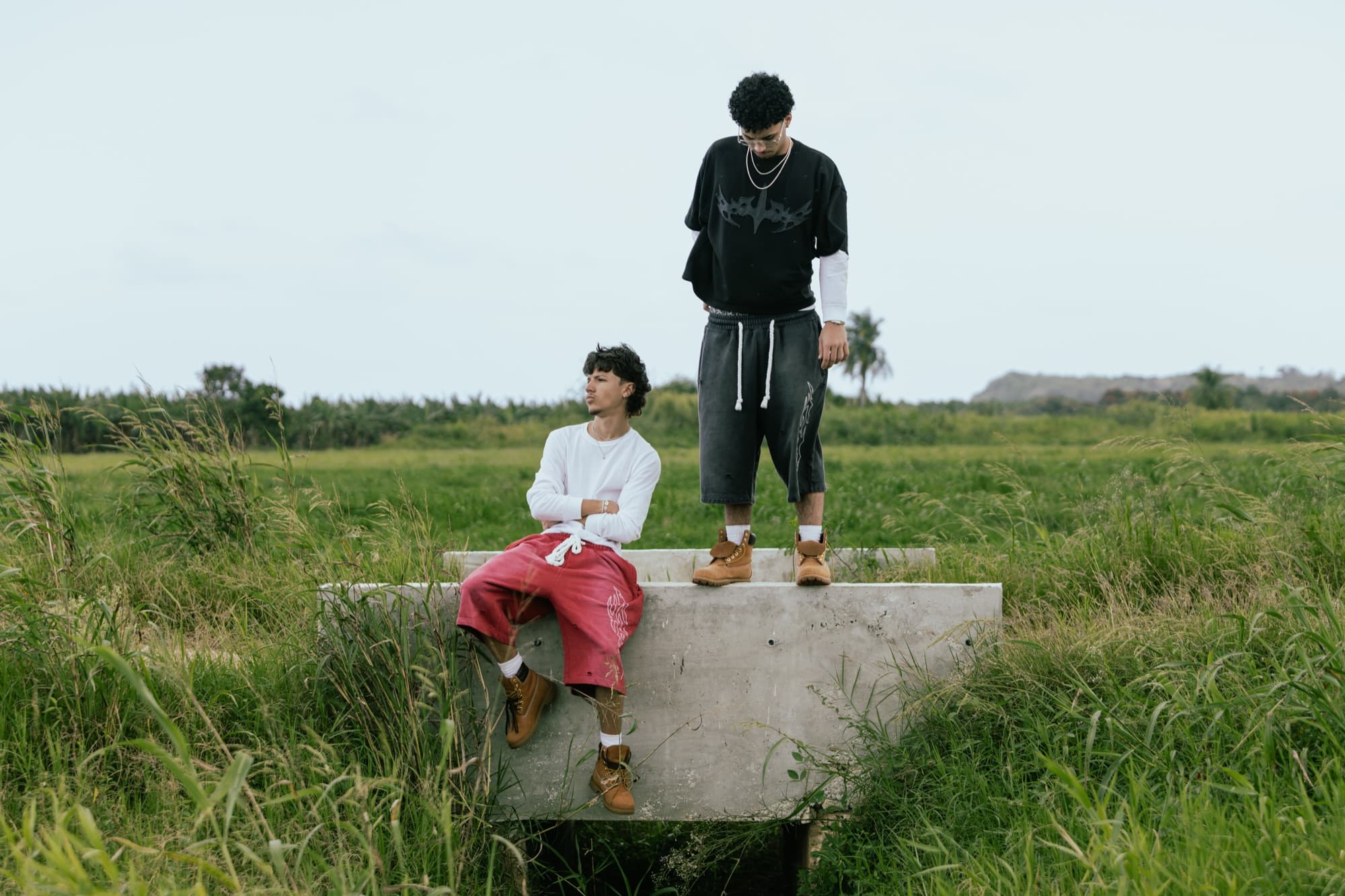 Model seated against raw concrete in the full fit