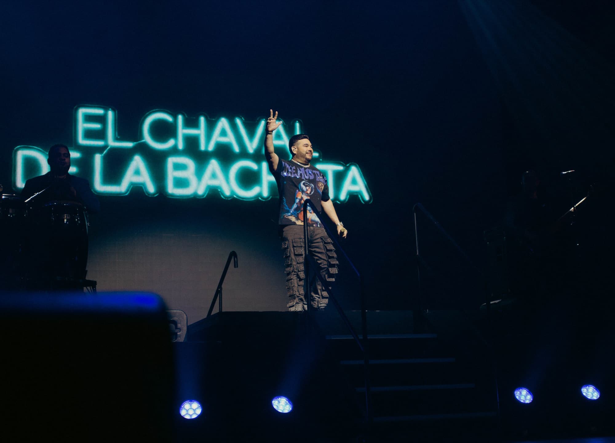 El Chaval waving beneath his name in neon