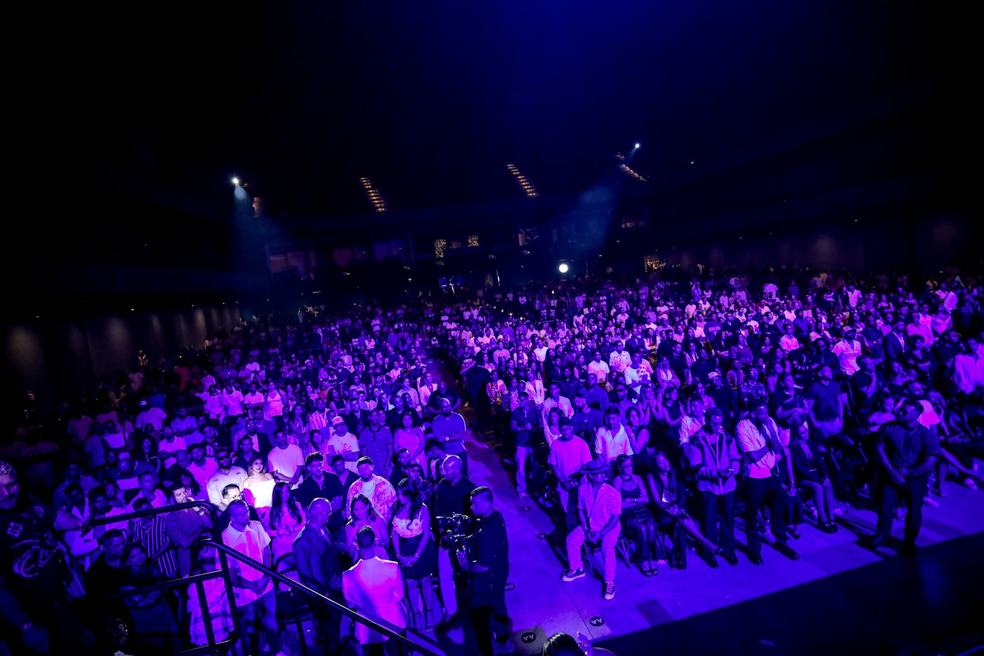 The arena crowd washed in purple light