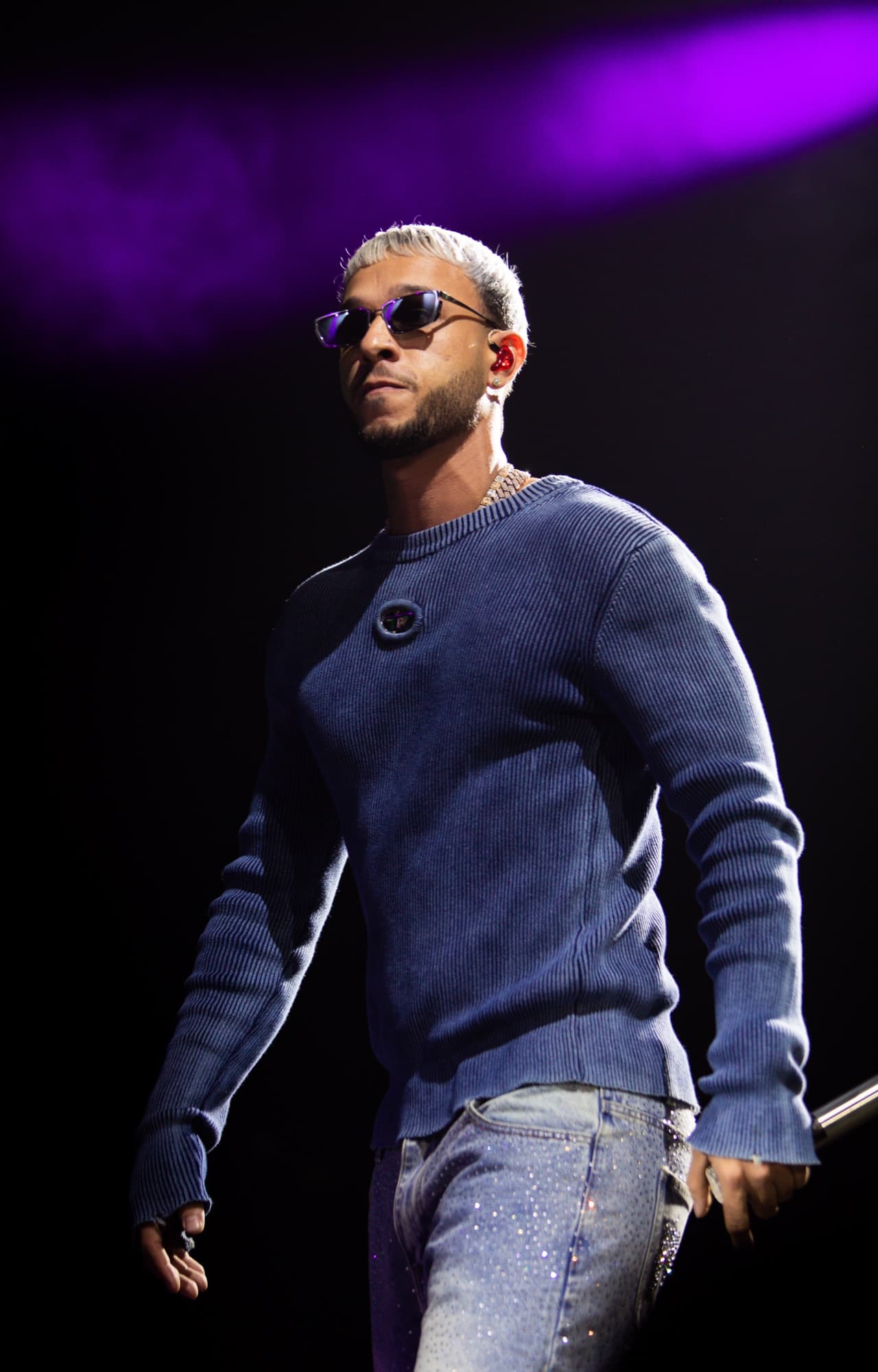 Guest artist in a navy sweater under cool blue light