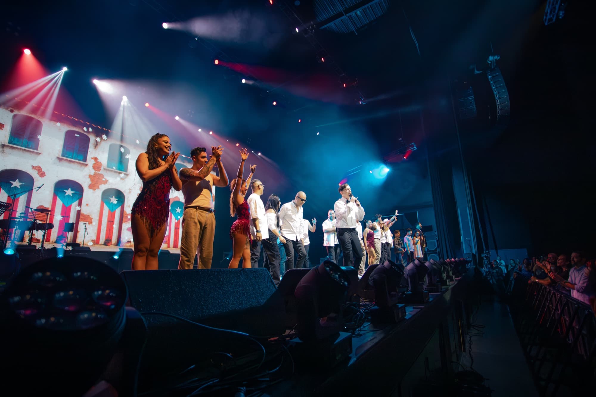 The full company taking a bow under blue lights