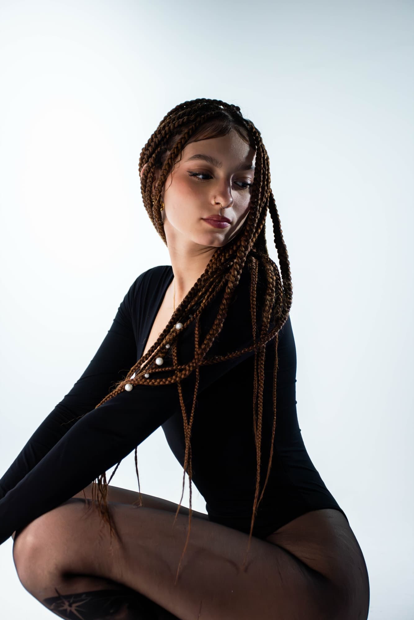 Studio pose with long braids sweeping across the frame