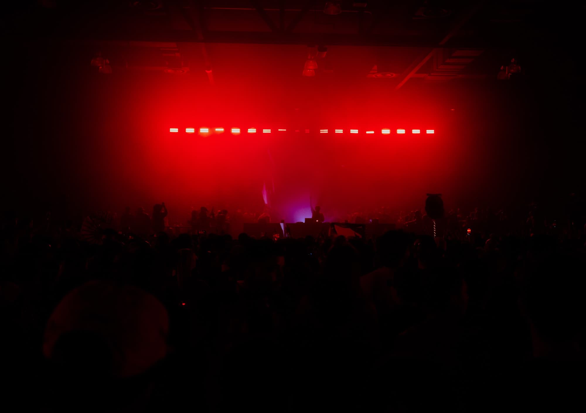 Red-lit stage wall glowing over the audience