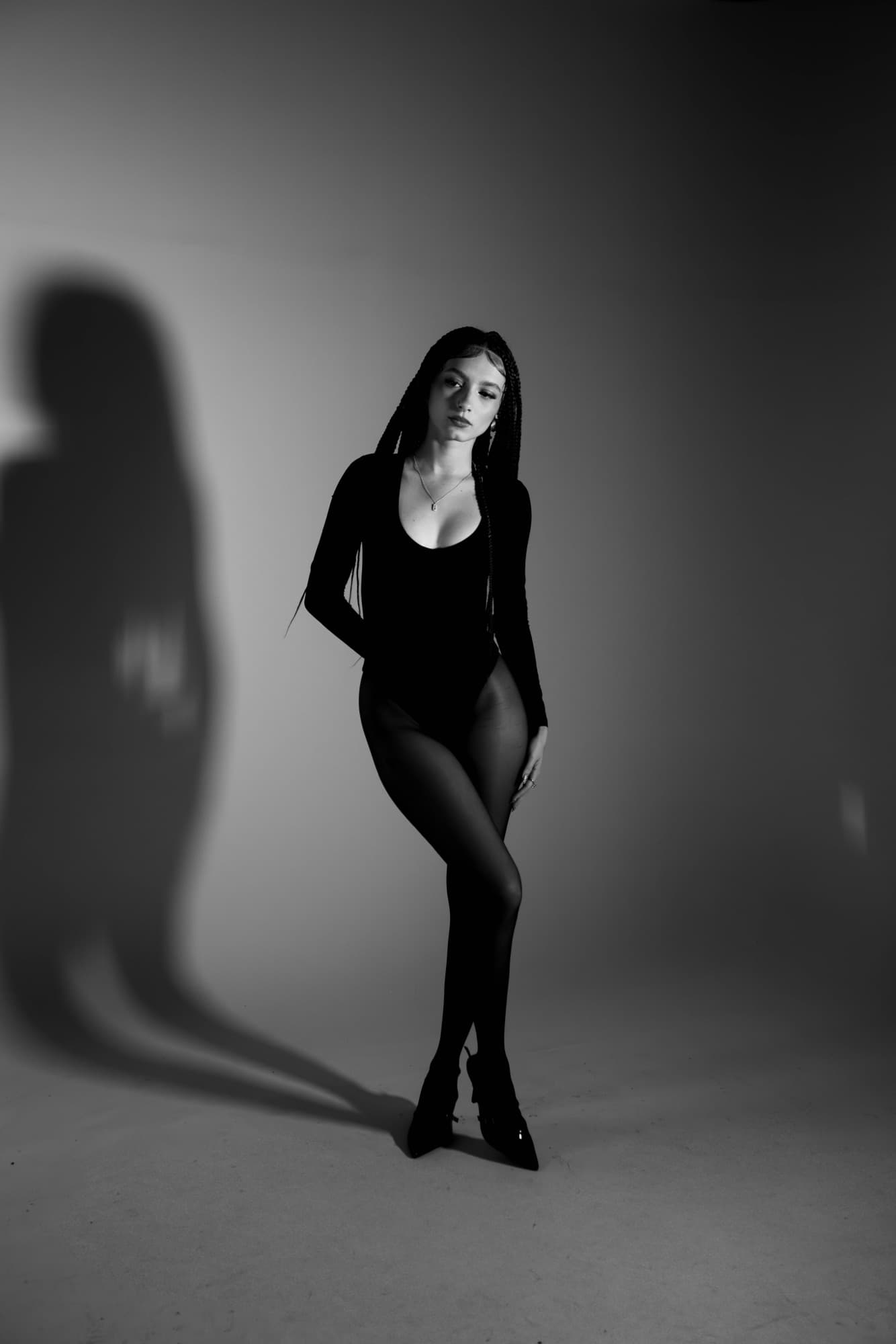 Black and white studio portrait with a cast shadow