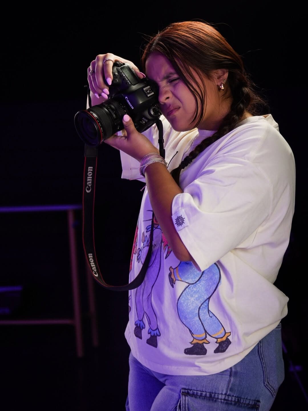 Salome Rosario shooting with her Canon under violet stage light