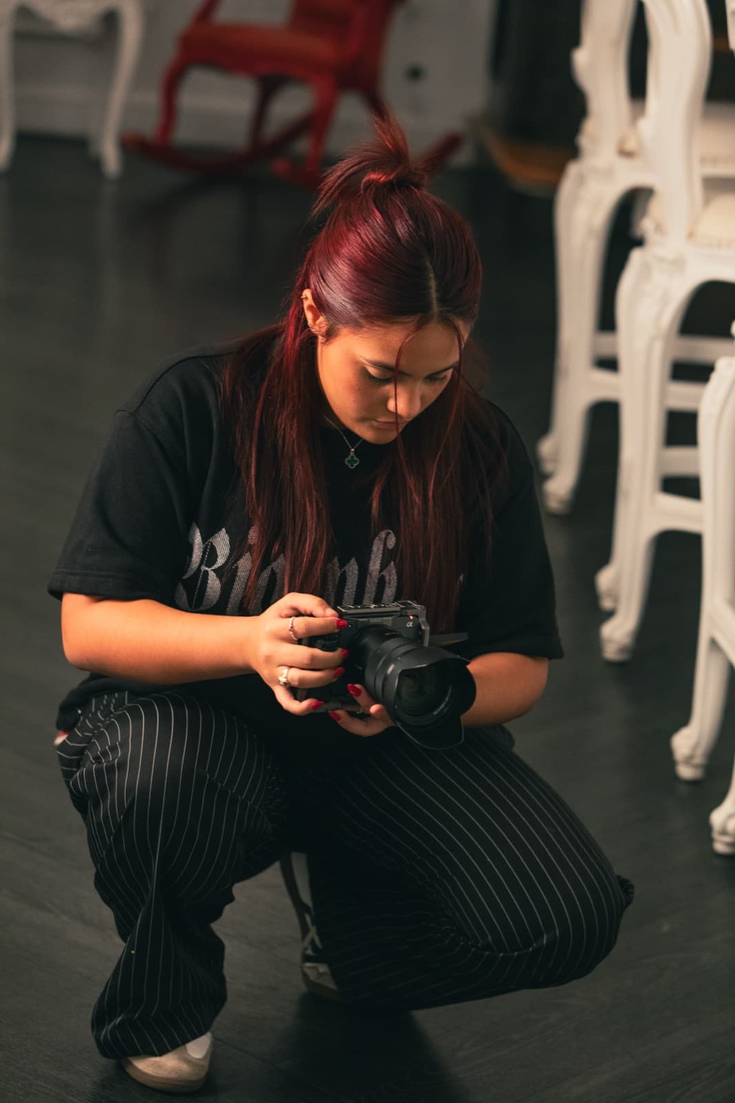 Salomé crouched down checking her camera between takes